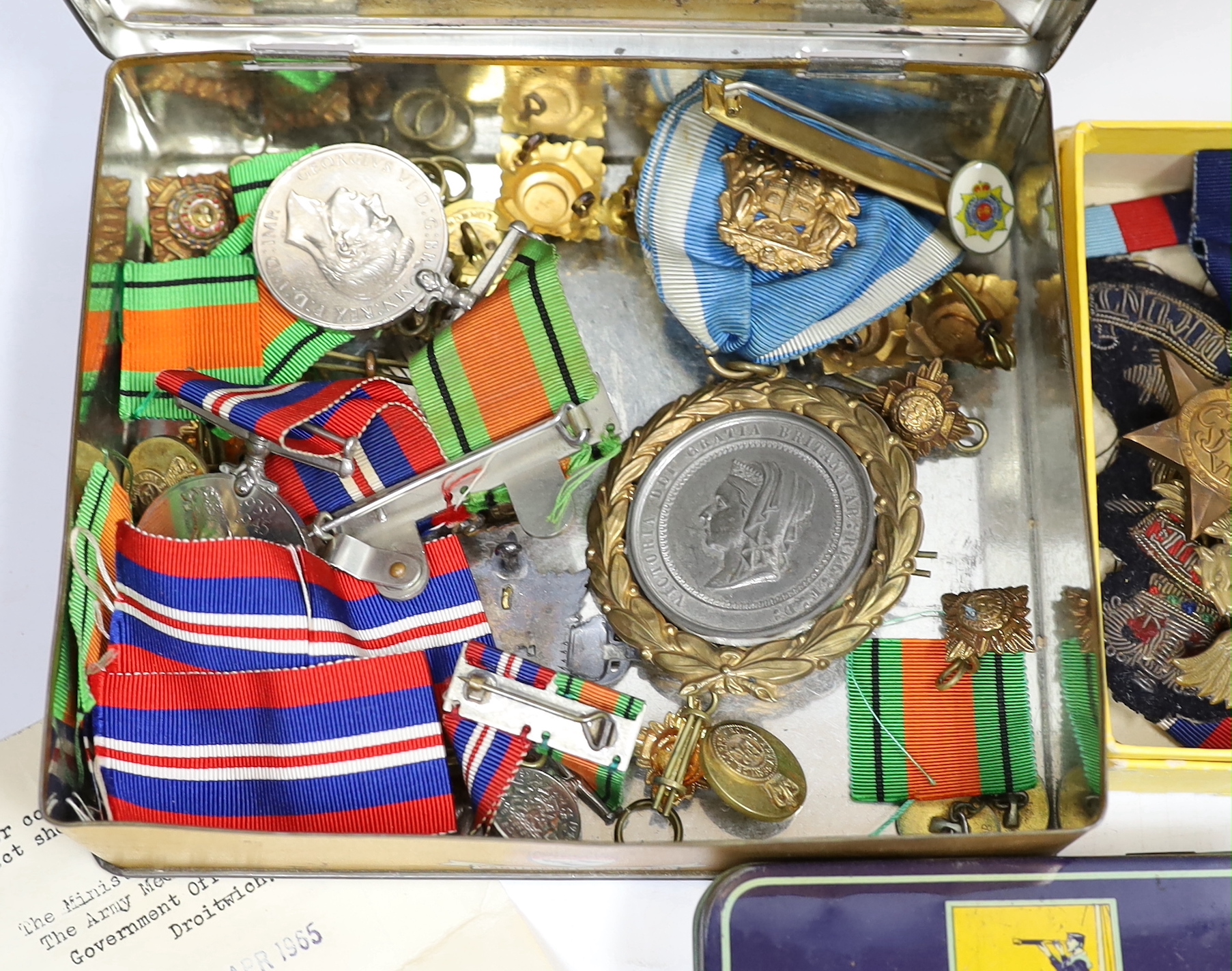 A collection of mostly unnamed WWI and WWII medals, cap badges and buttons, one pair named 24835 PTE. A. PRICE. R. W. KENT. R.
